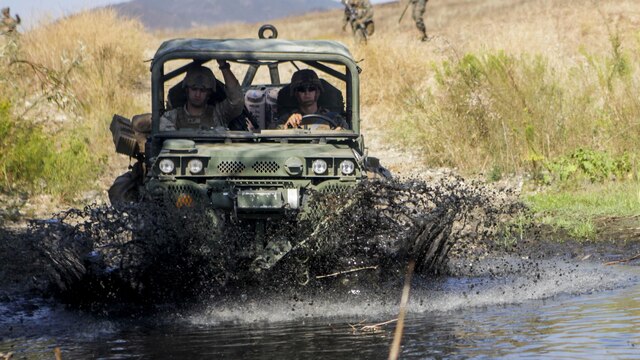 An internally transported vehicle fords a flooded road during an experimental exercise at Fort Hunter Liggett, Calif., Sept. 10, 2015. The experiment is designed to assist the Marine Corps warfighting Lab in capturing useful information in order for them to design a newer, more effective vehicle in the future.