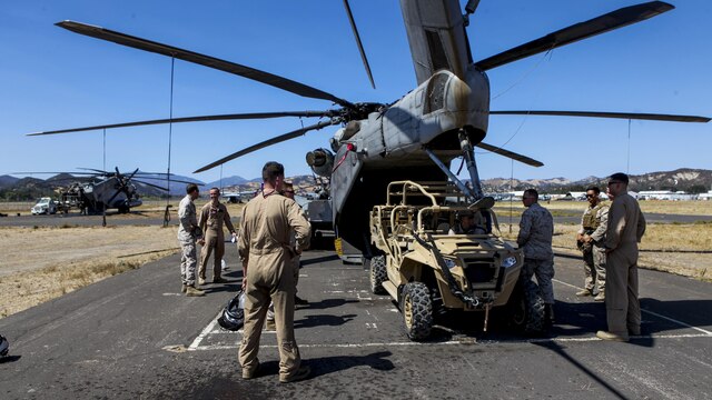 Marines with the Marine Corps Warfighting Lab observe as an Internally Transported Vehicle (ITV) is loaded on to a Sikorsky CH-53E Super Stallion Helicopter in preparation for an experimental field exercise at Fort Hunter Liggett, Calif., Aug. 31, 2015. The exercise allows the warfighting lab to assess the capabilities of the ITVs and determine new recommendations for the design of ITVs to come.